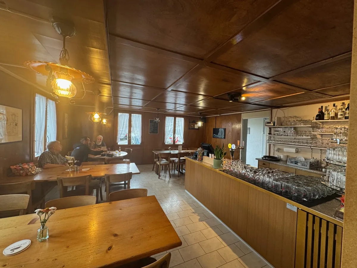Gaststube im Restaurant Schwanen mit Holztischen und Bar
